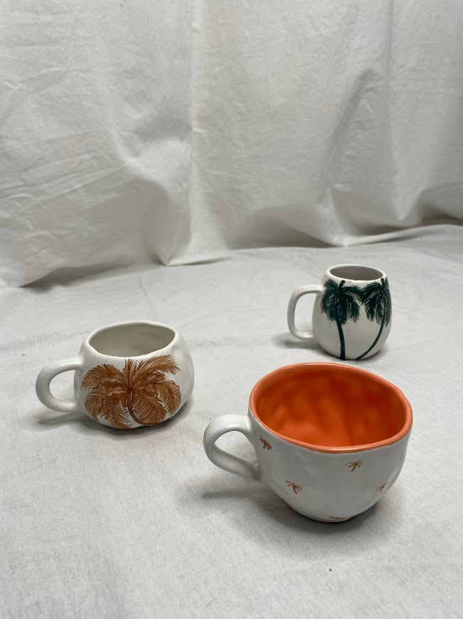 Three different palm tree mugs shot in a studio with linen backdrop