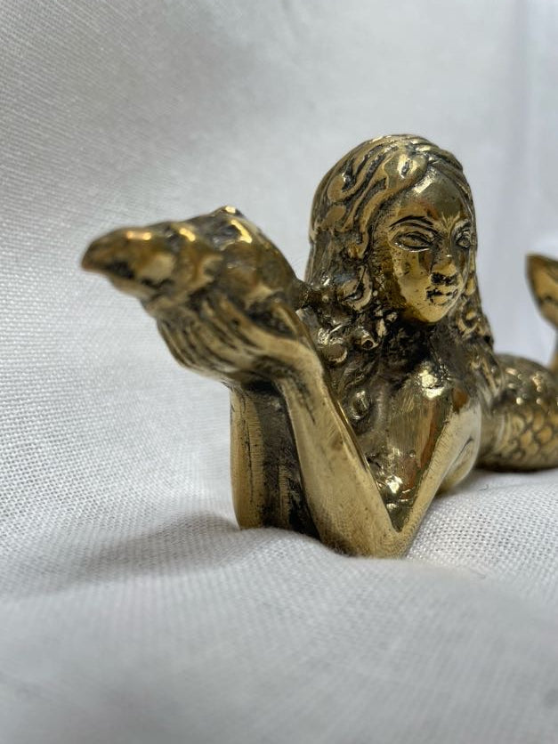 Close up face details of mermaid on side, holding shell