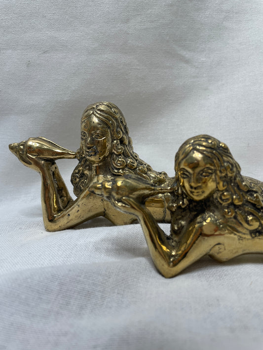 Details of Brass mermaids laying on sides with shells