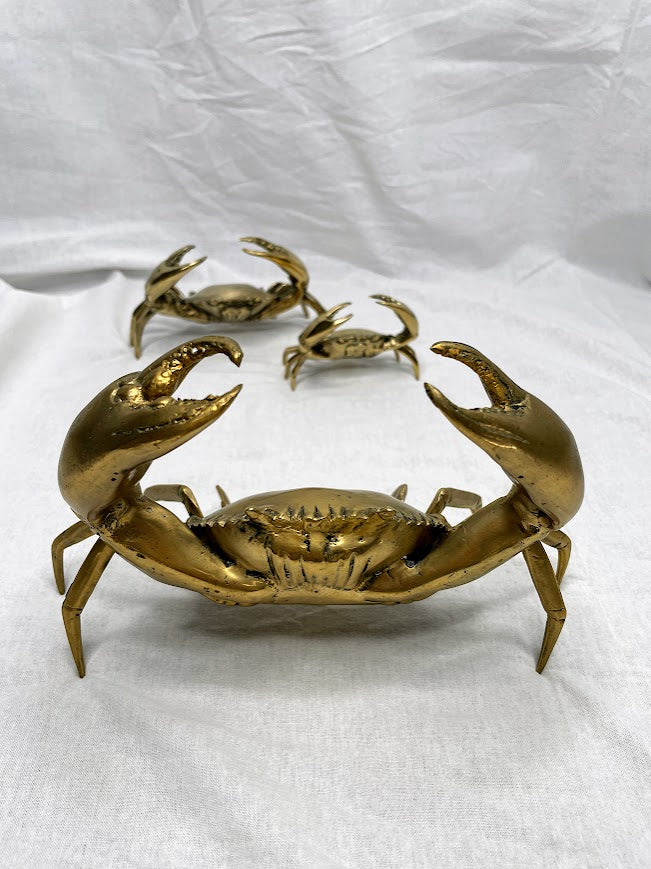 Three differently sized brass crab statues