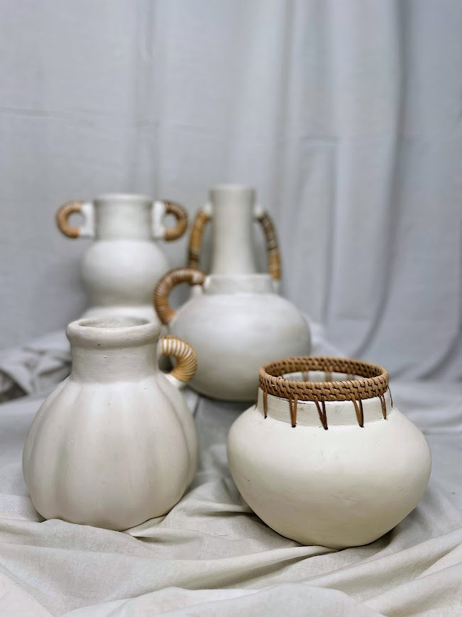 Collection of different white pottery vases and pots with rattan detailing