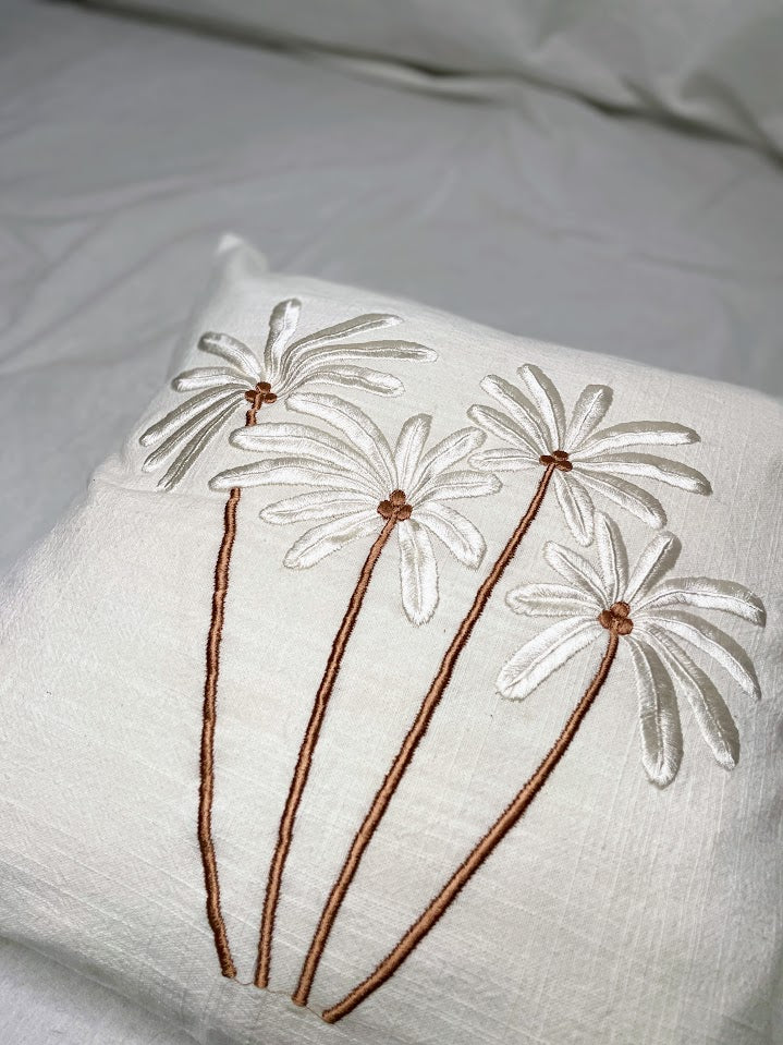 Details of hand sewn palm trees on a linen cushion cover