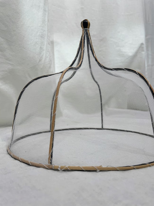 Close up details of mesh and rattan food cover in a studio