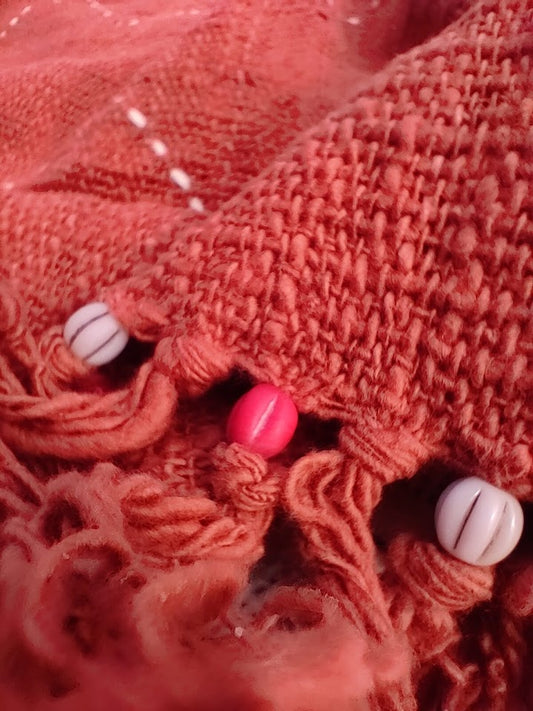 Close up details of beads and tassles on a throw rug