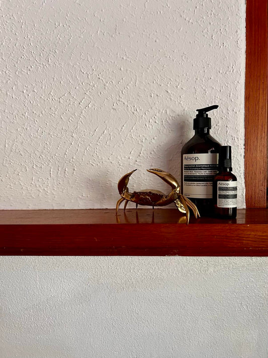 Brass crab decor on shelf