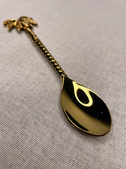 Brass teaspoon with palm tree detailing on handle and end of spoon