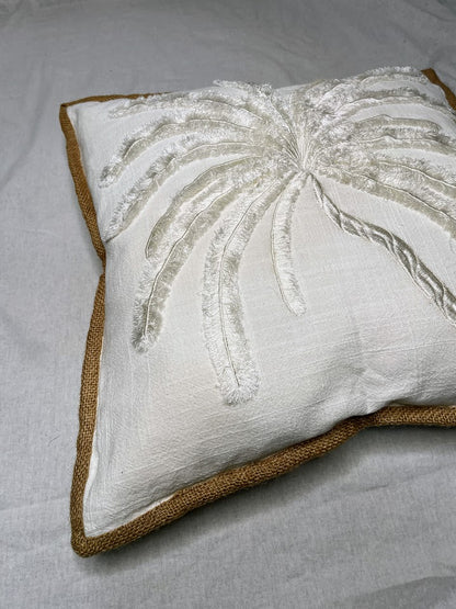 Close Up details of White Linen Cushion with large white hand sewn palm tree detailing and brown border 