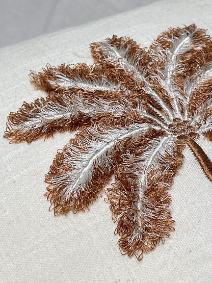 Close up details of hand sewn palm tree on a linen cushion cover