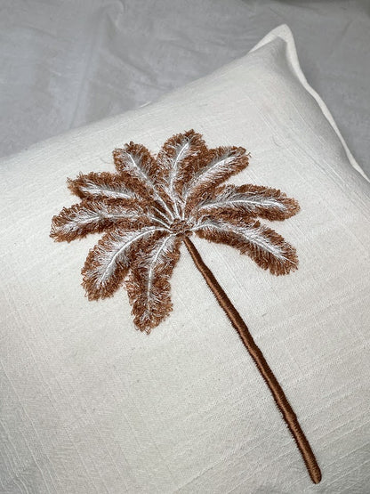 White linen cushion with brown palm tree hand sewn onto front