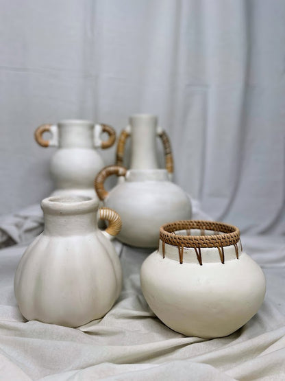 Collection of different white pottery vases and pots with rattan detailing