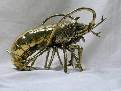 Side view of large brass lobster statue