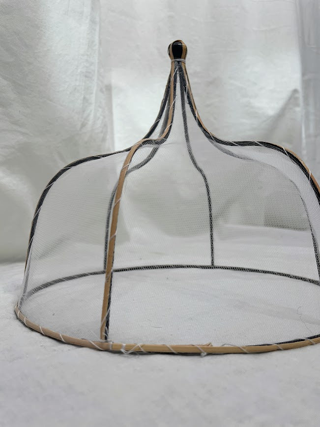 Close up details of mesh and rattan food cover in a studio