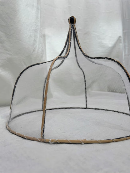 Close up details of mesh and rattan food cover in a studio