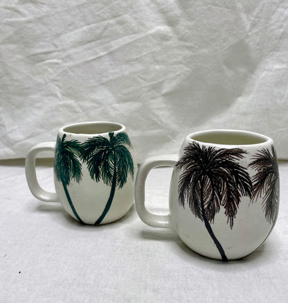 Handcrafted ceramic coffee cups featuring hand painted palm trees 