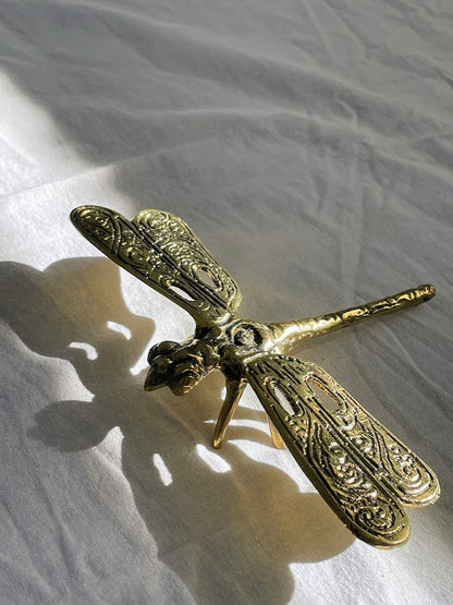 Brass Dragonfly with light coming in through holes in the wings